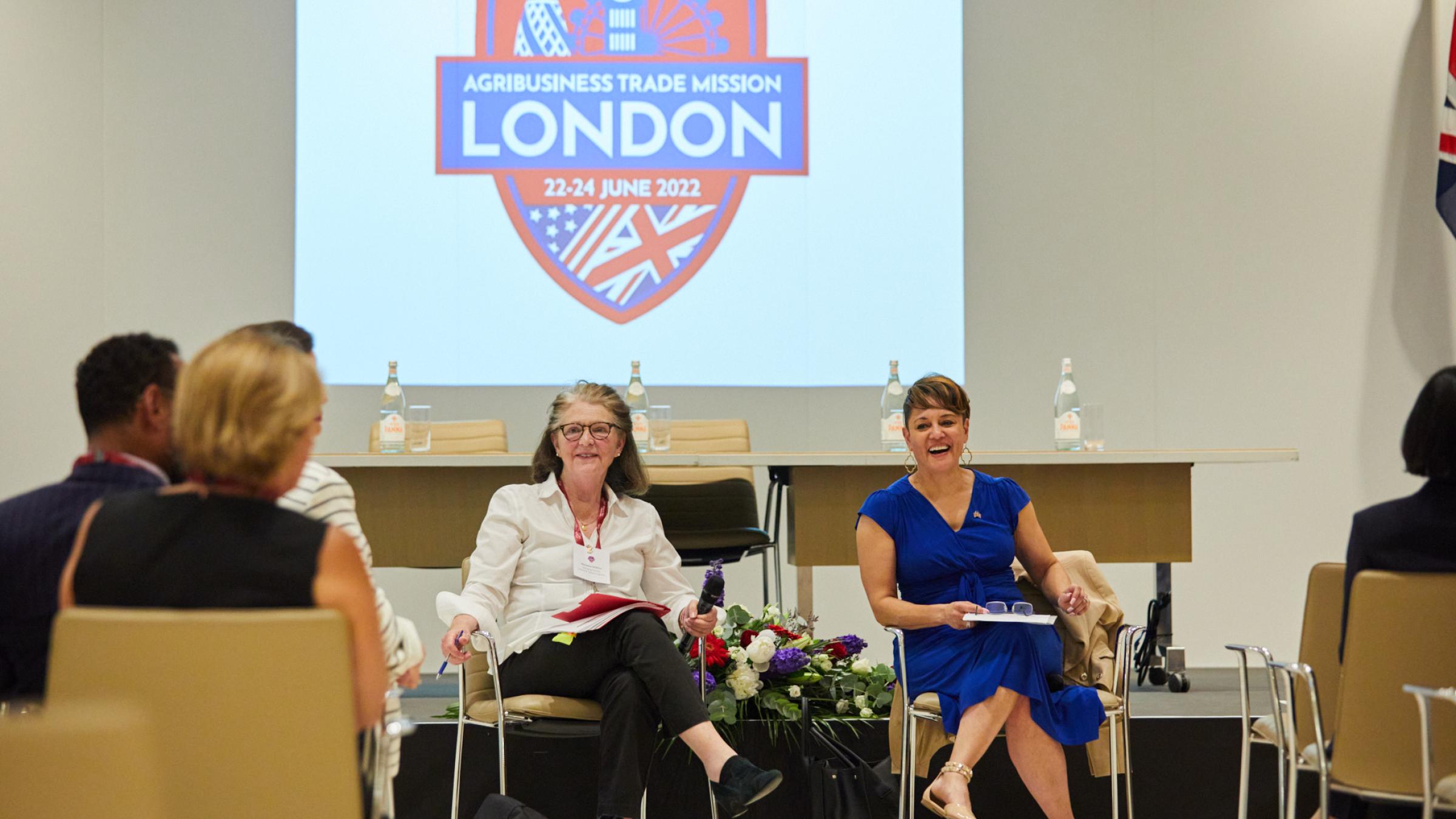 Women in front of screen with trade mission logo