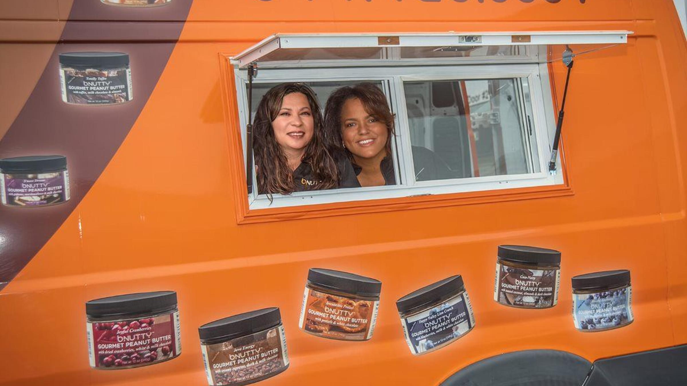 Two women Carol Podolak and Joy Thompkins poke their head out a window of a van that they use for their BNutty business.