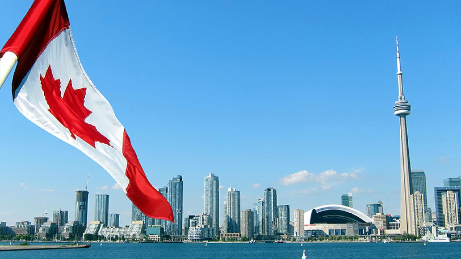 Toronto city skyline with Canadian flag in foreground