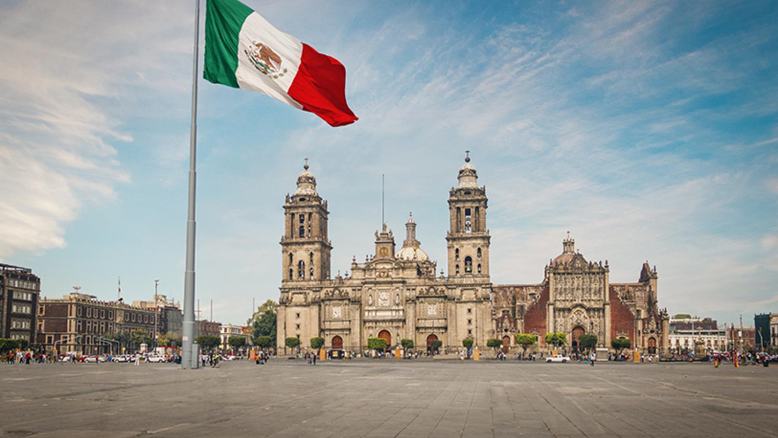 Plaza in Mexico City with flag in foreground.