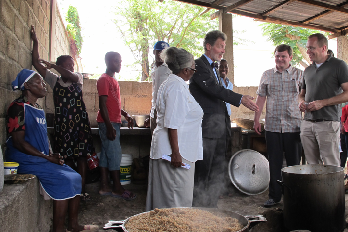 Marie Juslene Pelerin (in white), principal of Haiti’s National School of Ganthier, shows the preparation of a school meal to U.S. Ambassador to Haiti Peter Mulrean (to her right) and FAS Administrator Phil Karsting (far right). Marie Juslene Pelerin (in white), principal of Haiti’s National School of Ganthier, shows the preparation of a school meal to U.S. Ambassador to Haiti Peter Mulrean (to her right) and FAS Administrator Phil Karsting (far right).