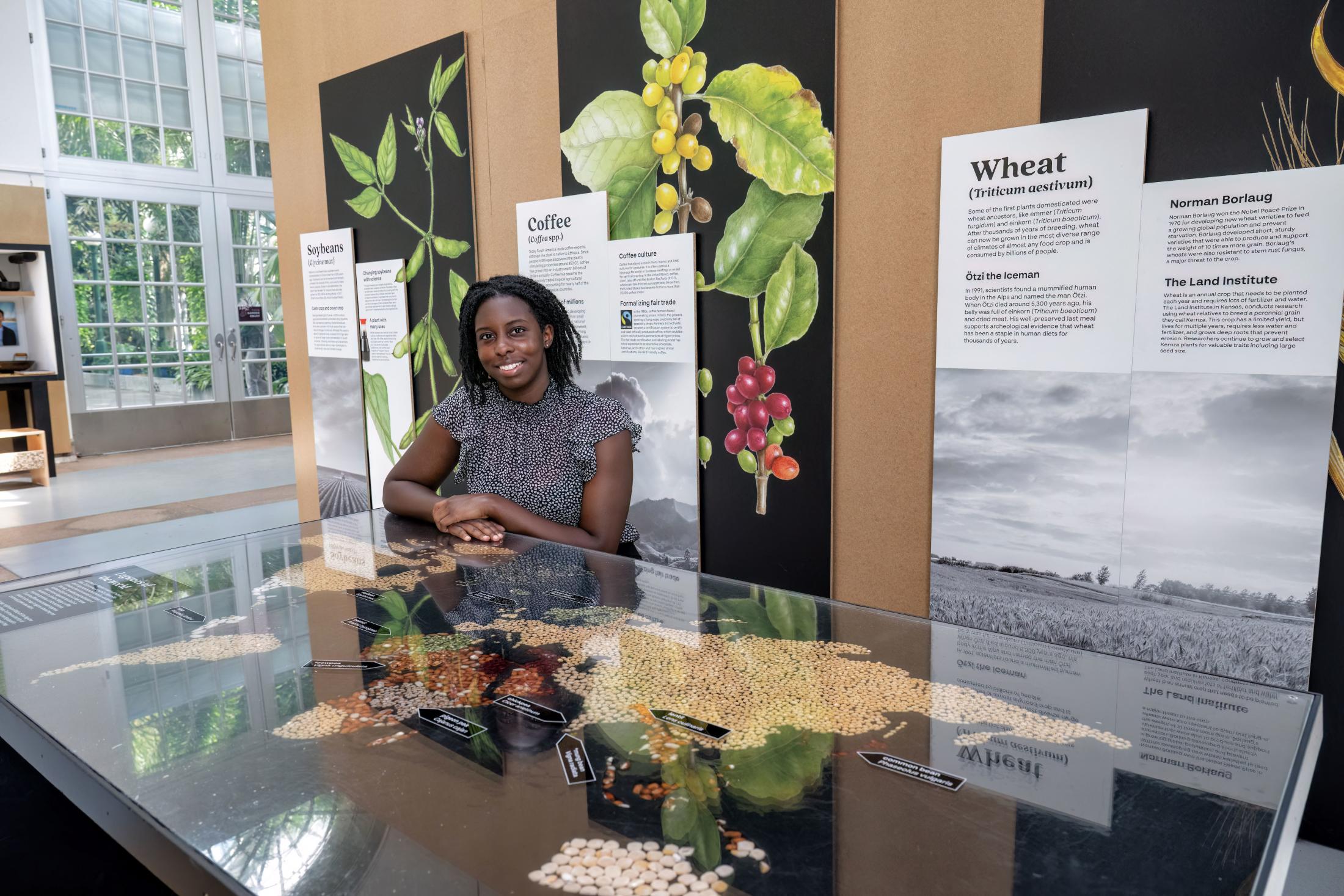 A woman sits at a table that has a large map of the world.