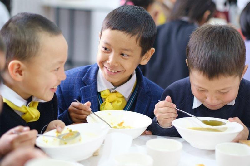 Children enjoying lentil soup prepared from USDA-donated commodities. Karool village, Kyrgyzstan. Photo credit: Mercy Corps staff.